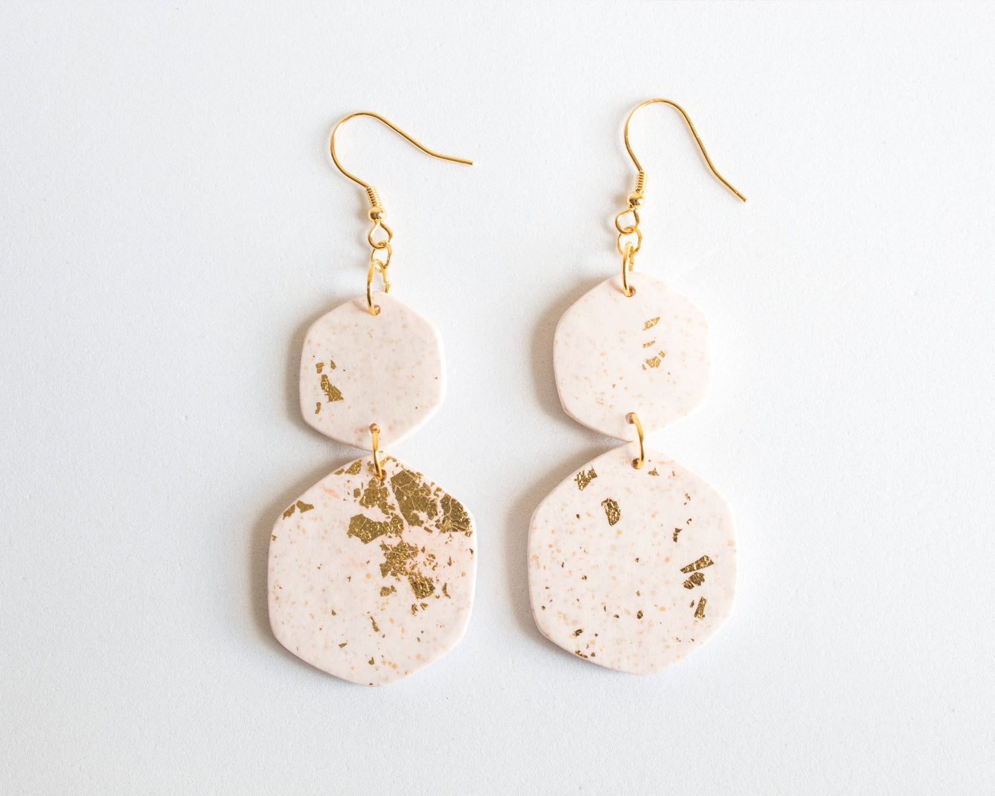 Close-up detail of white and gold leaf boho earrings, highlighting the texture and handcrafted quality of the clay.
