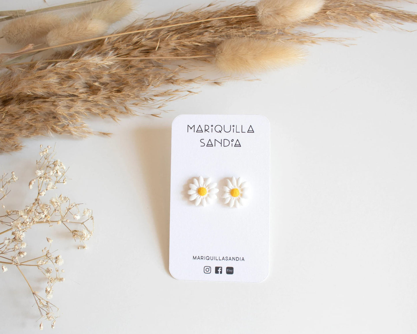 Close-up of handcrafted daisy earrings made from clay