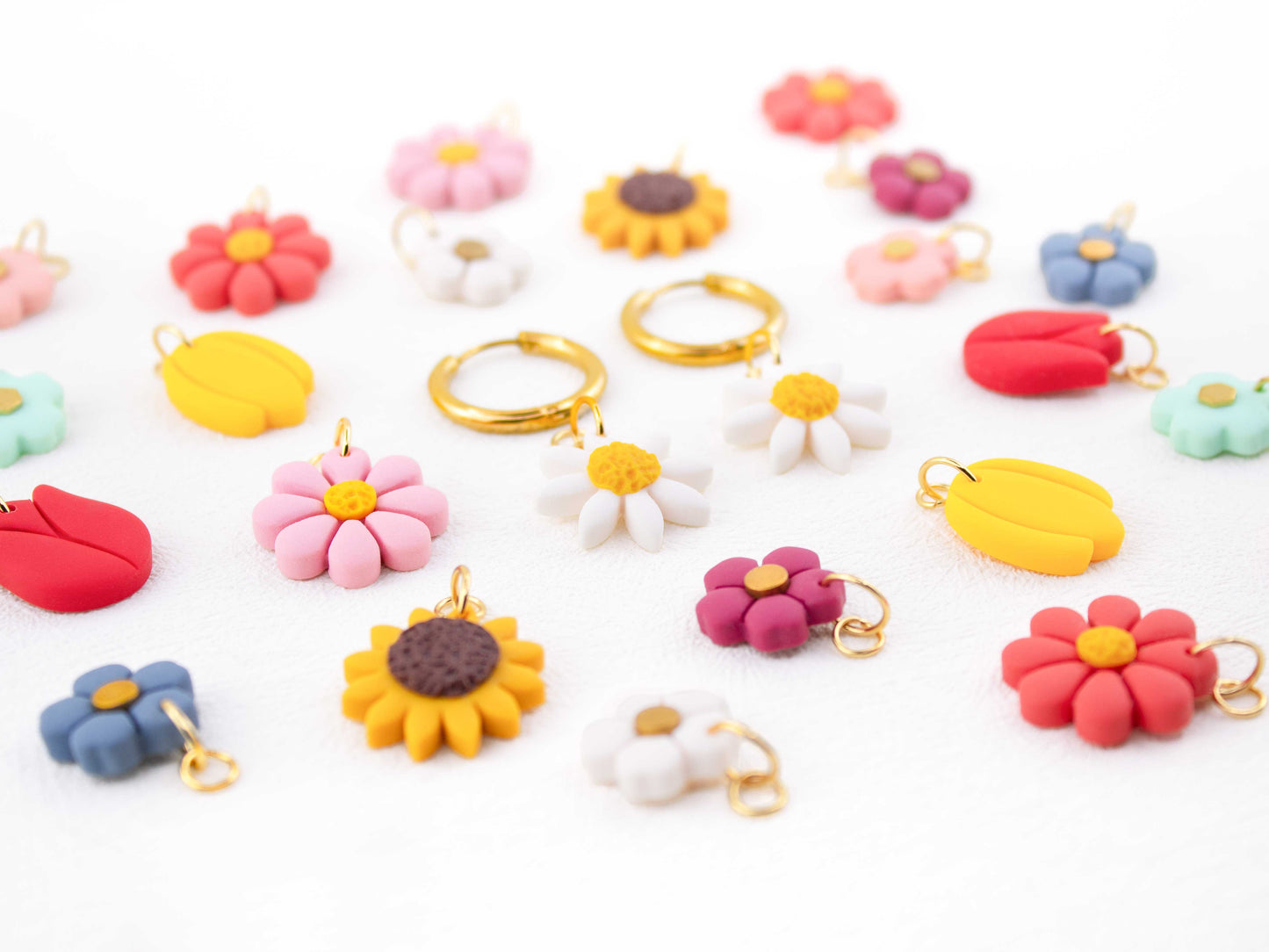 Beautiful earrings with interchangeable charms featuring flowers, daisies, sunflowers, tulips, and colorful flowers.