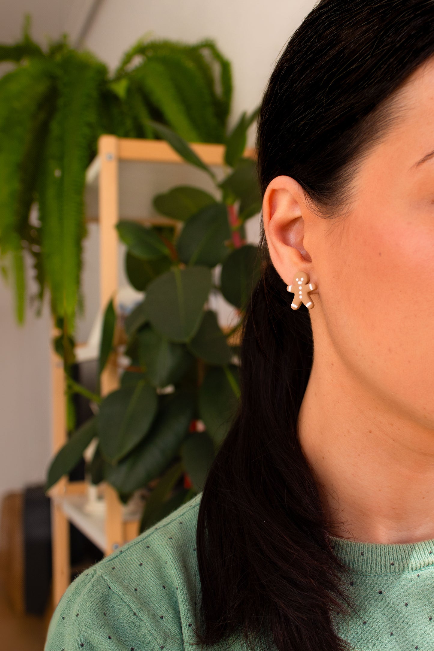 Close-up of handmade gingerbread man cookie stud earrings. Lightweight and hypoallergenic, ideal for Christmas celebrations and holiday gifts.