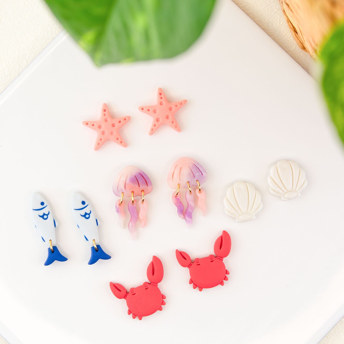 Ocean inspired stud earrings handmade in clay featuring starfish jellyfish seashell crab and fish