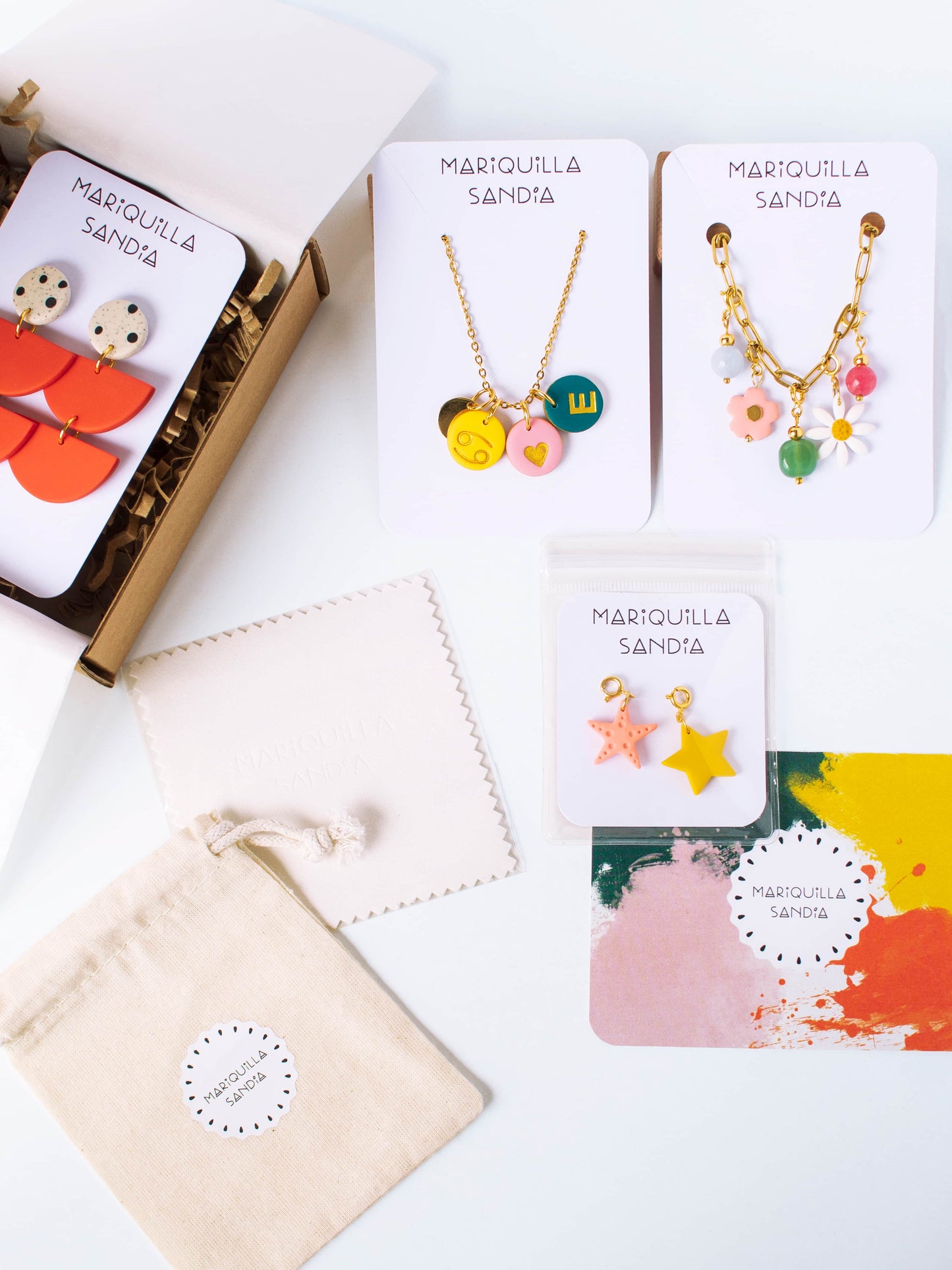 Mariquilla Sandía packaging with jewelry display cards, linen pouch, and cleaning cloth.