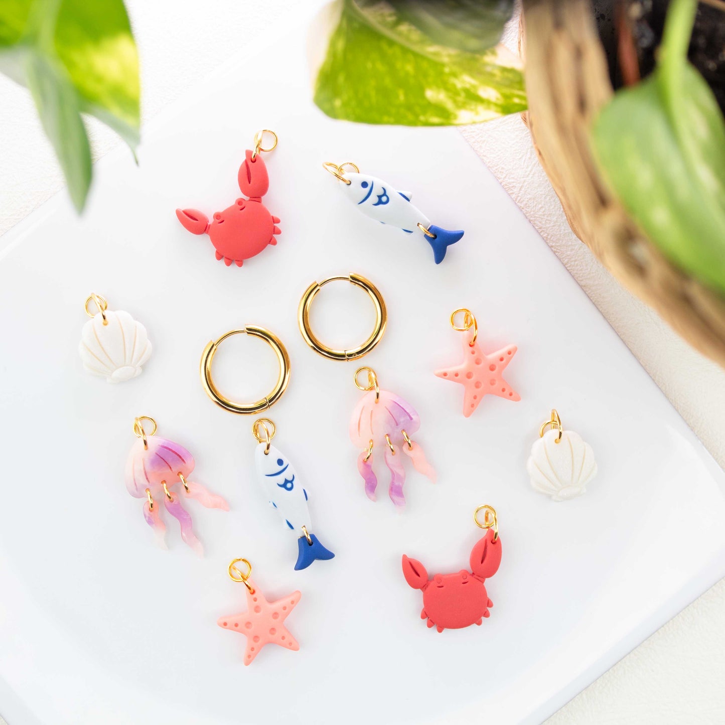 gold charm hoop earrings with ocean charms starfish fish jellyfish seashell crab