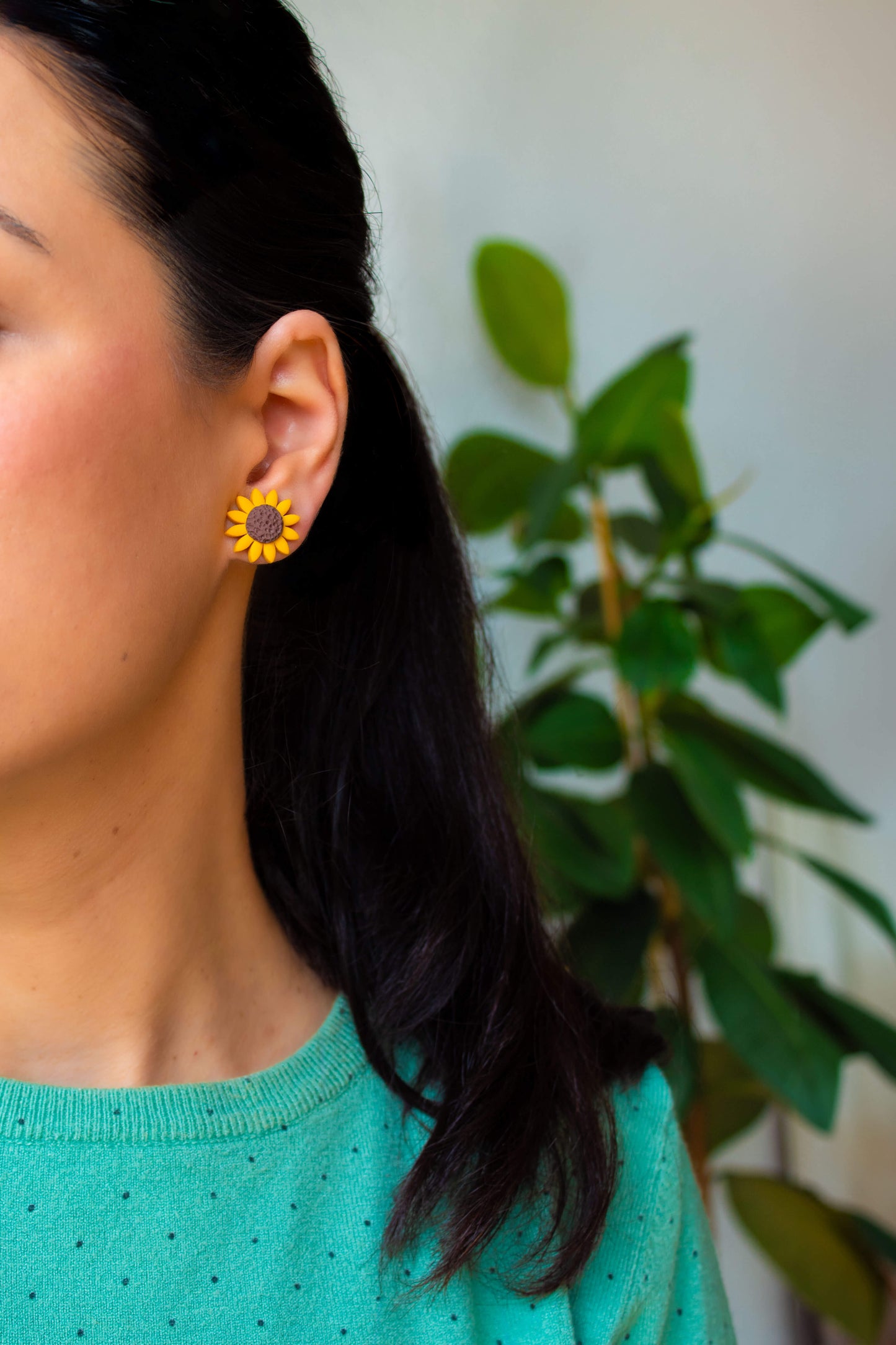 Sunflower stud earrings worn by a model, highlighting their bright and detailed floral design.