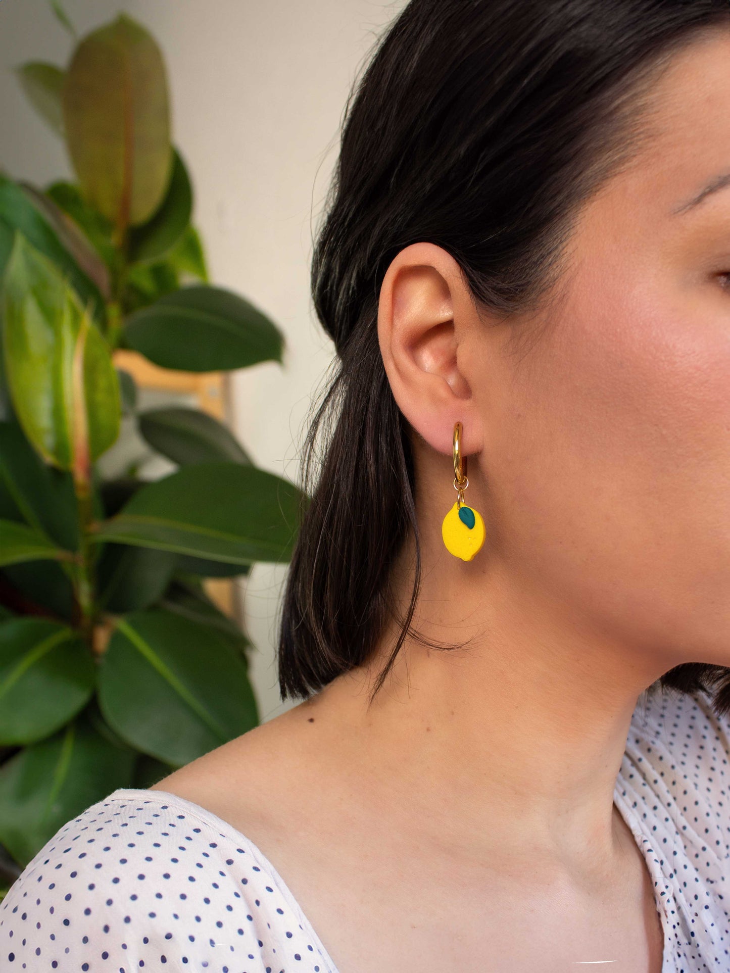 model wearing gold hoop earring with lemon charm summer jewelry