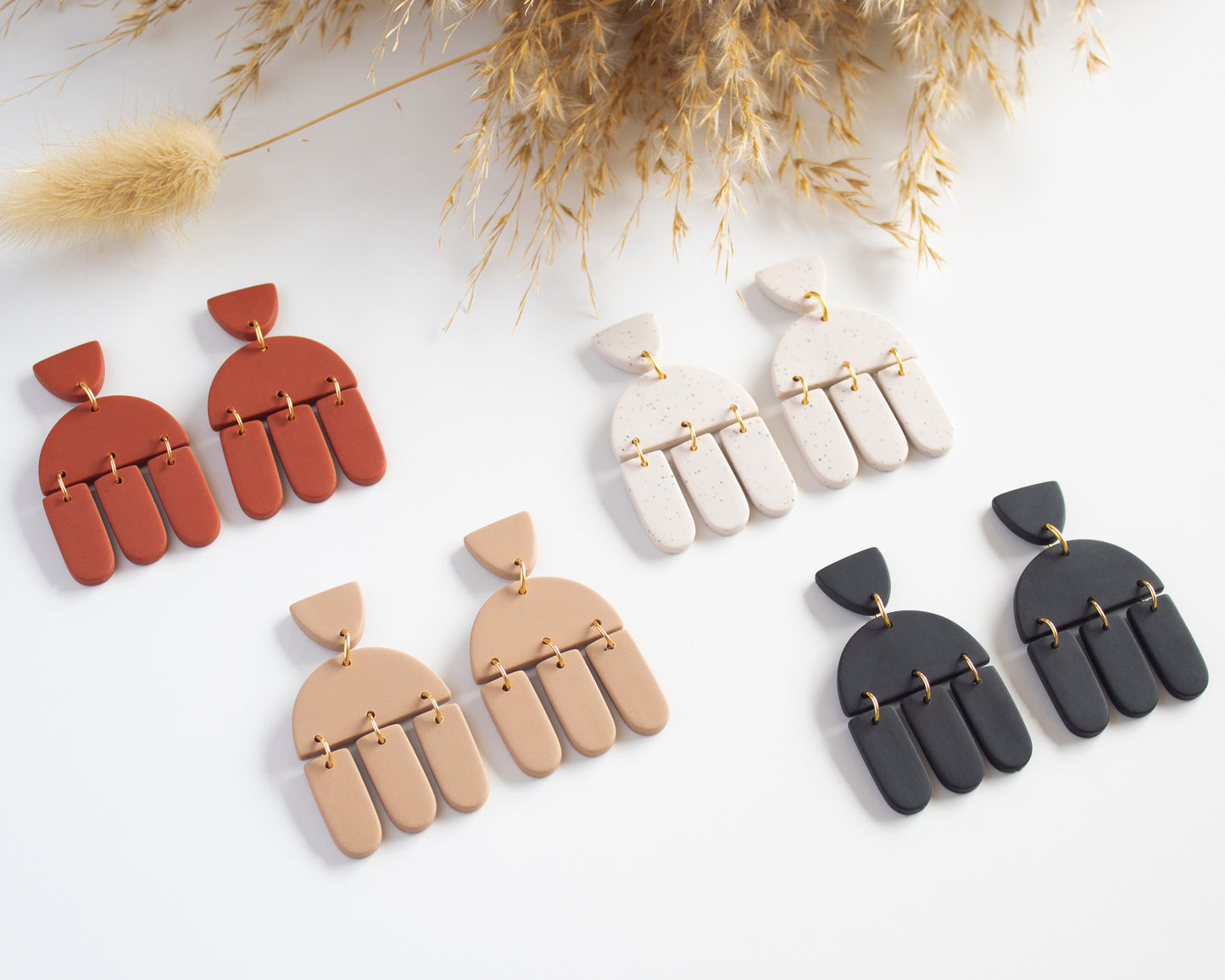 Collection of boho-style geometric earrings, handmade with polymer clay, available in various colors, lightweight and hypoallergenic.