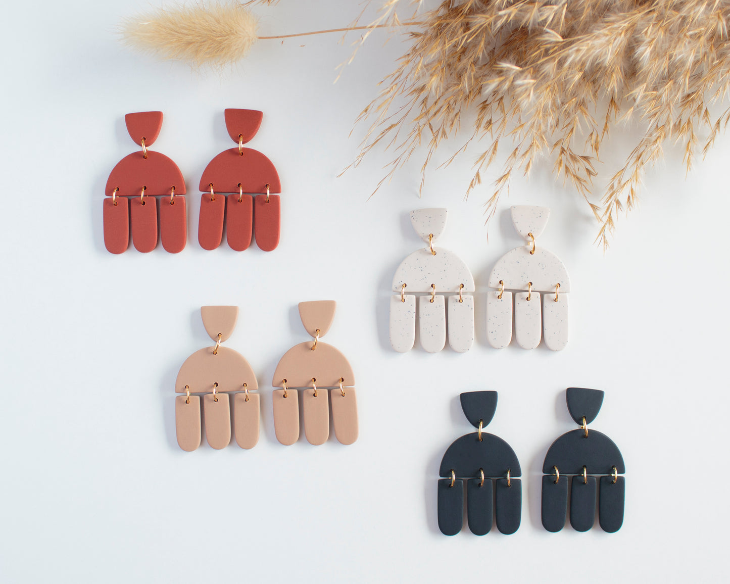 Collection of boho-style geometric earrings, handmade with polymer clay, available in various colors, lightweight and hypoallergenic.