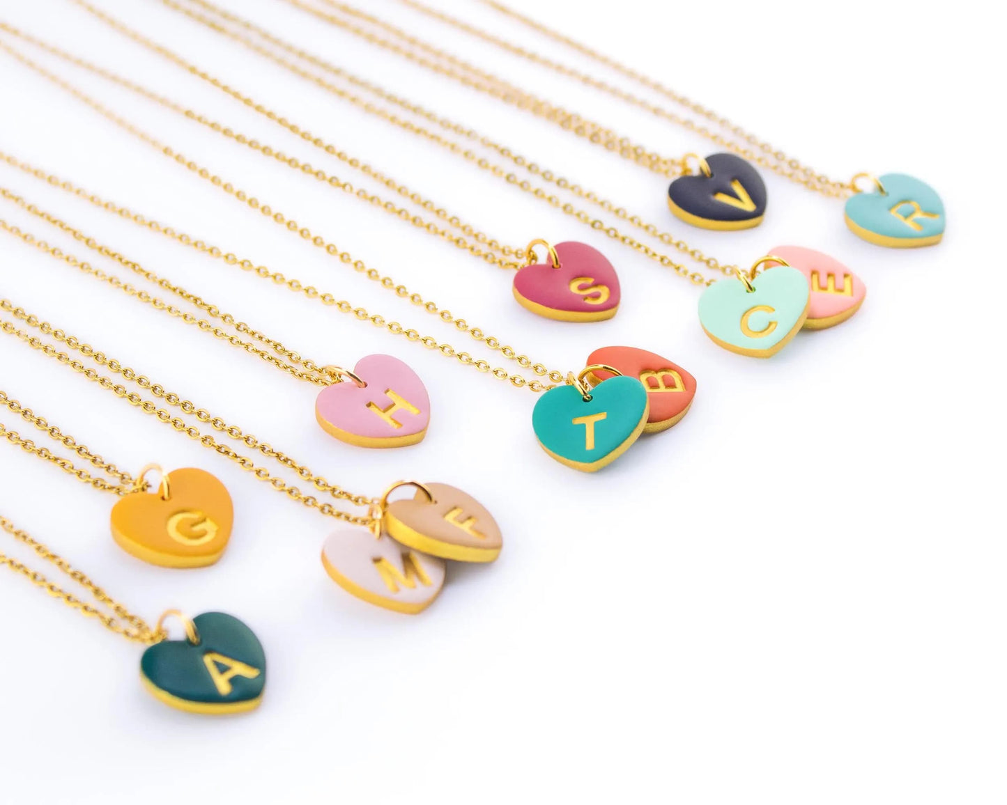 Row of colorful personalized heart necklaces on golden chains