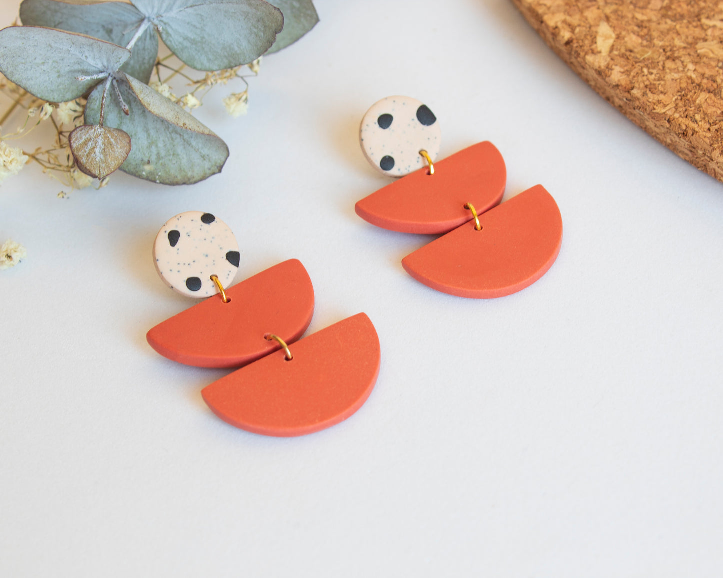 Close-up of coral boho dangle earrings, handcrafted with care.