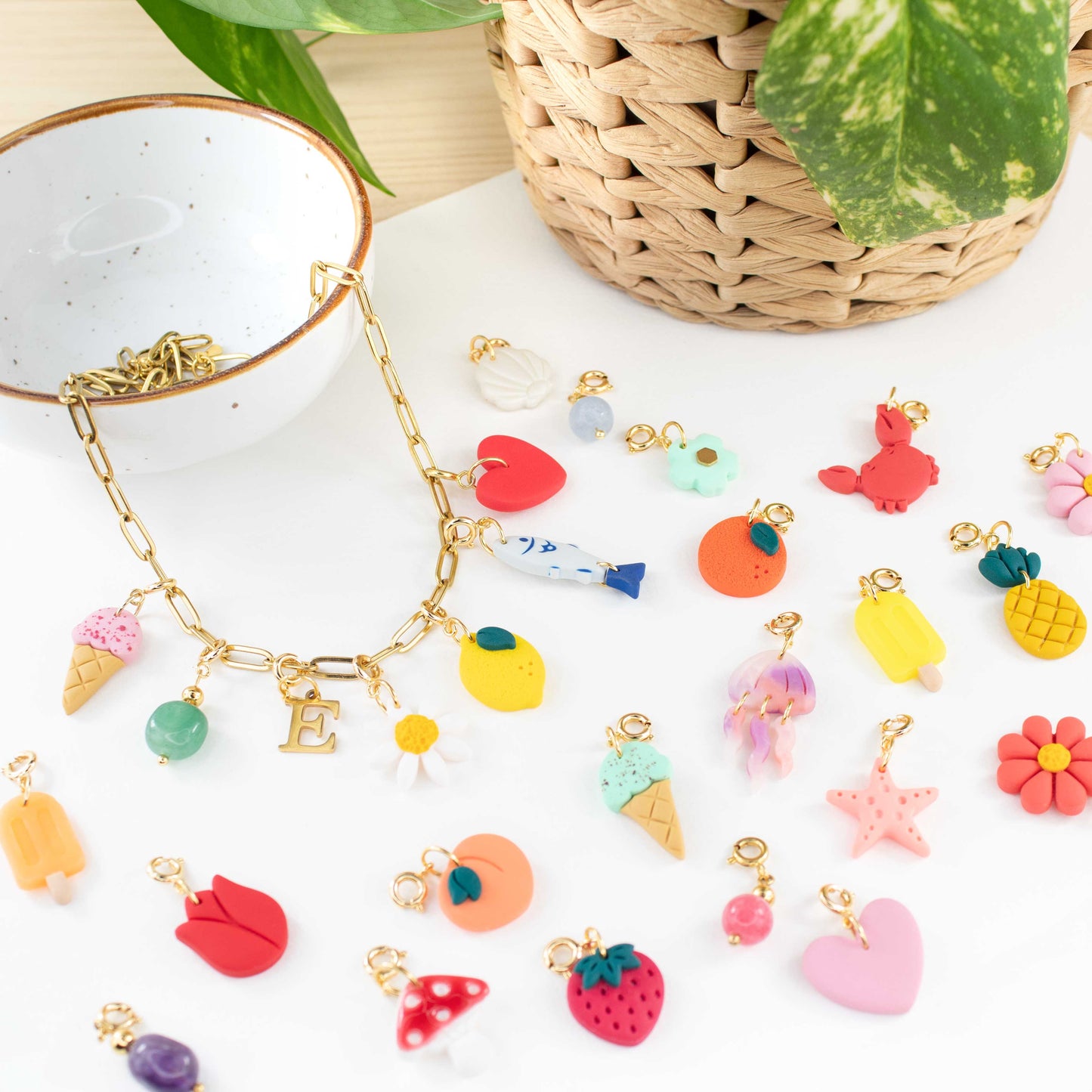 Handmade clay charms featuring watermelons, lemons, daisies and strawberries, displayed on a white background for personalized summer jewelry