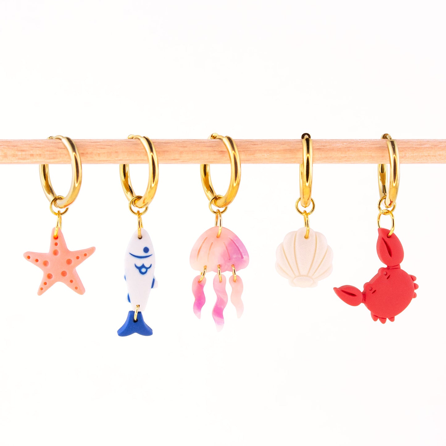 gold charm hoop earrings with ocean charms starfish fish jellyfish seashell crab