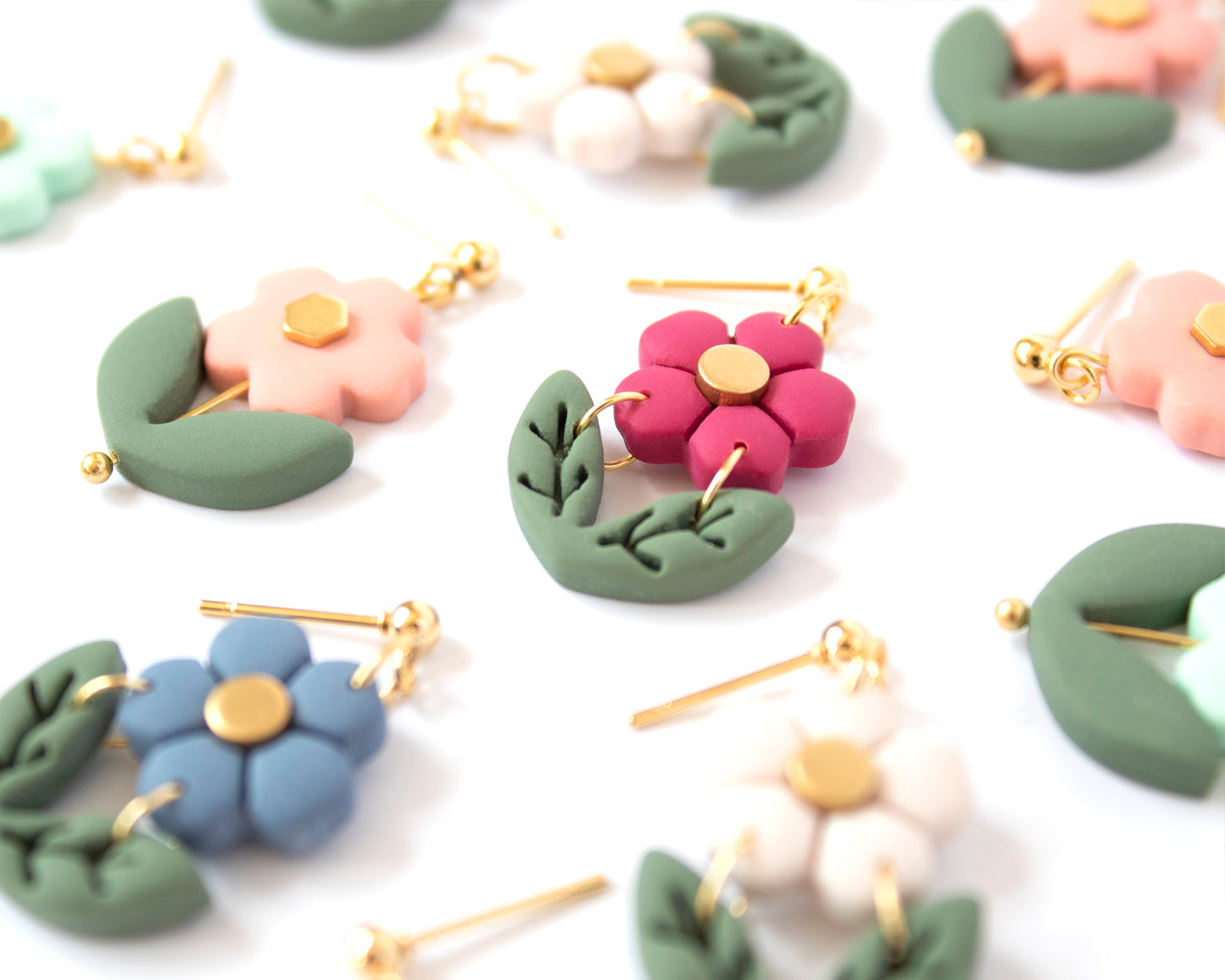 Close-up of statement flower beaded earrings, handmade with 18K gold plated posts, featuring a raspberry flower.
