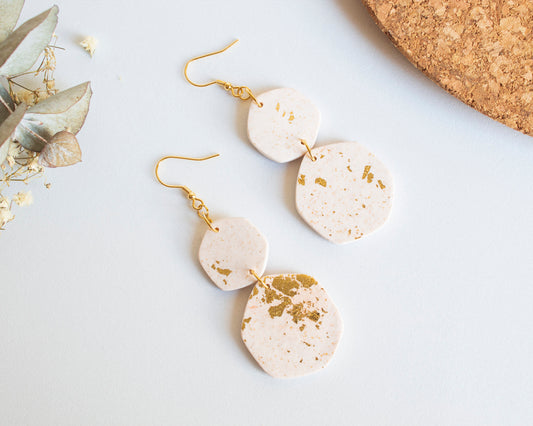 Handmade boho earrings in white clay with gold leaf accents, featuring a unique geometric design and hypoallergenic hooks.