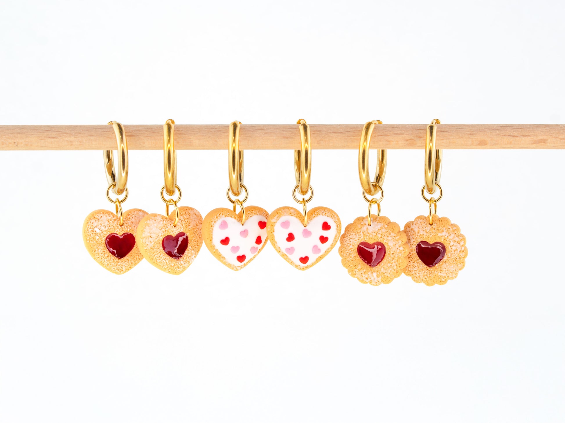Cookie charm hoop earrings with heart shaped biscuit charms hanging on gold hoops