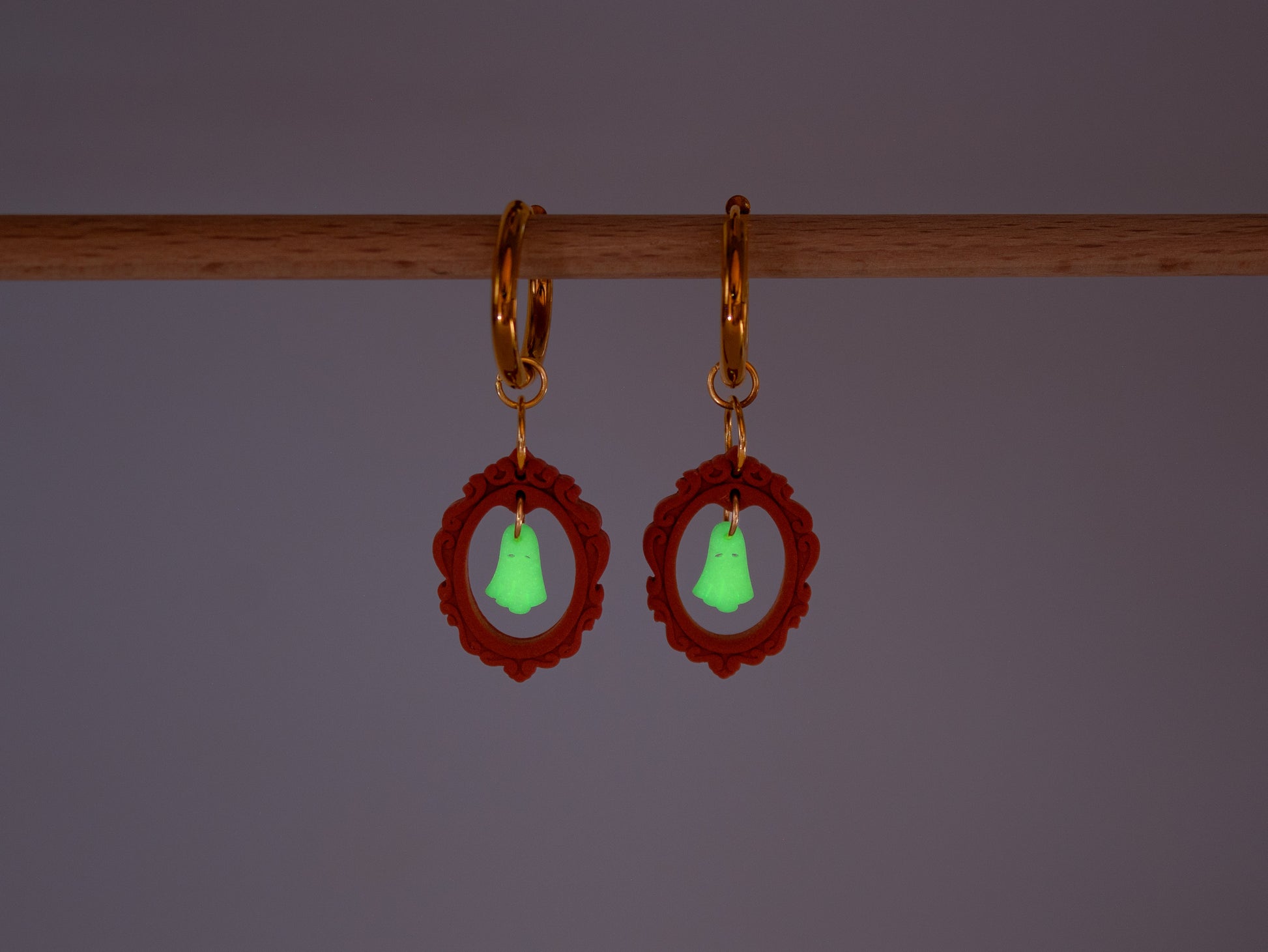 Handmade Halloween charm hoop earrings featuring cute ghost pendants inside red vintage frames on a bright background.