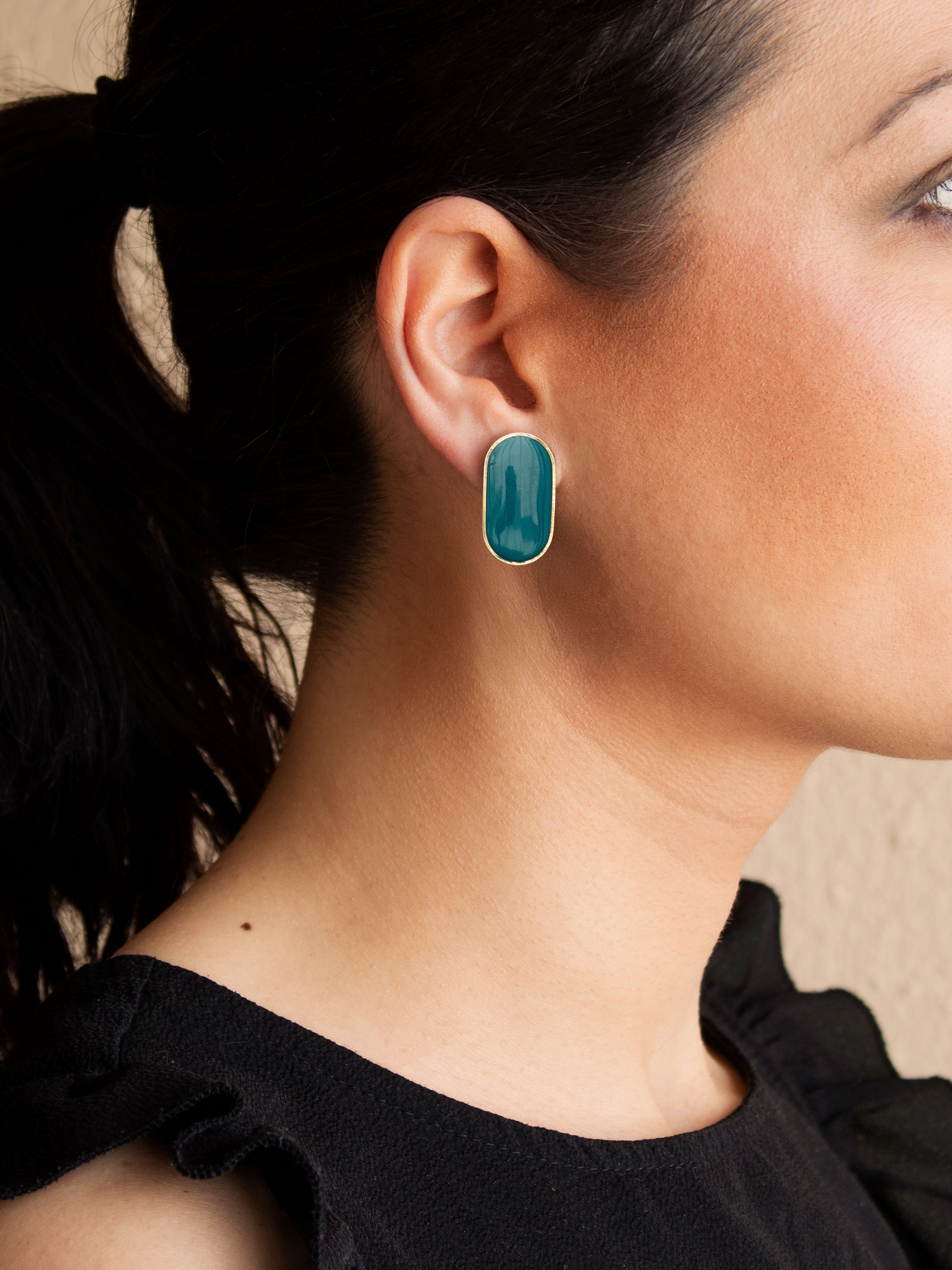 Green stud earrings with detachable gold chain fringe worn on ear