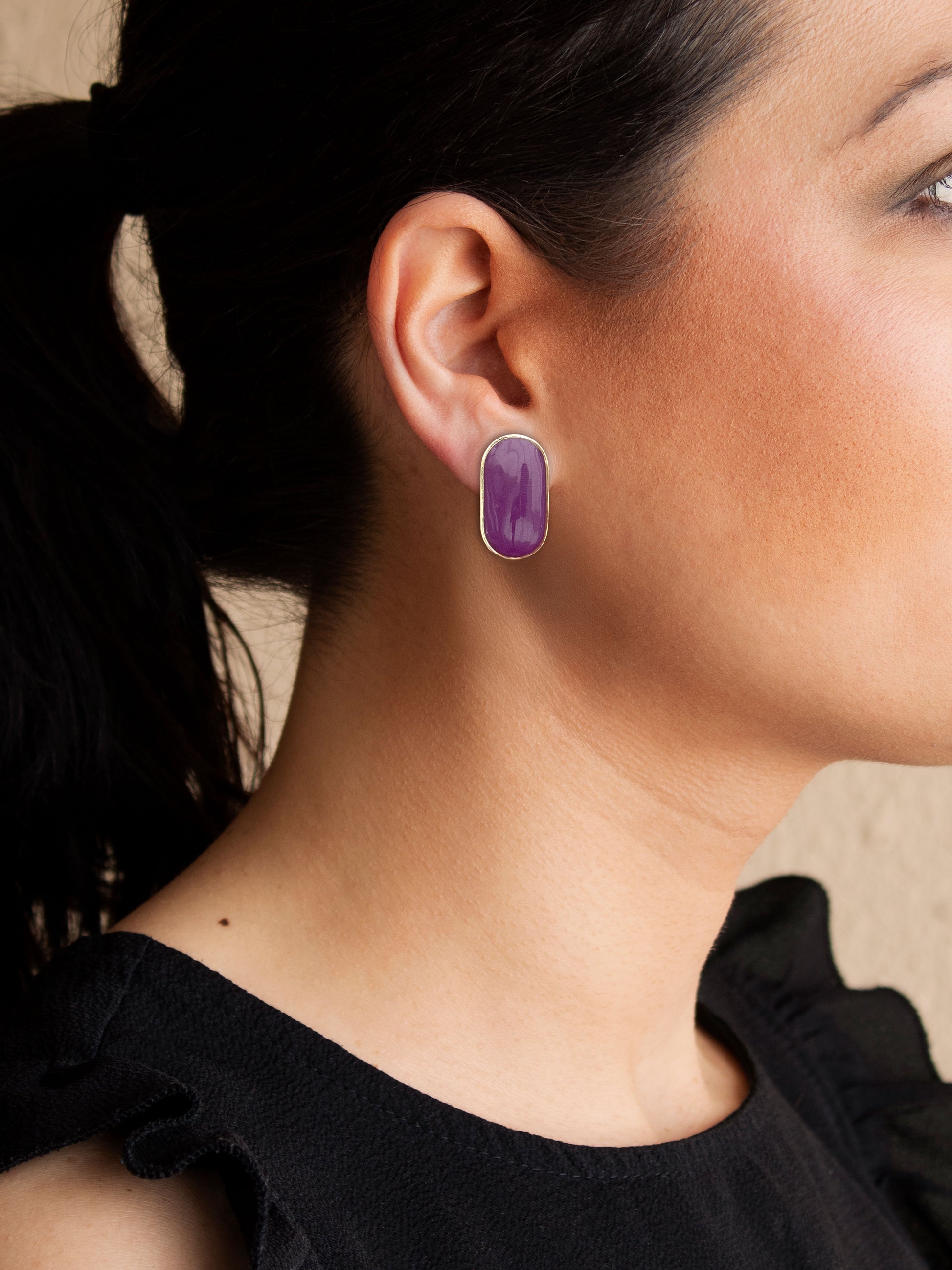 Purple stud earrings with detachable gold chain fringe worn on ear
