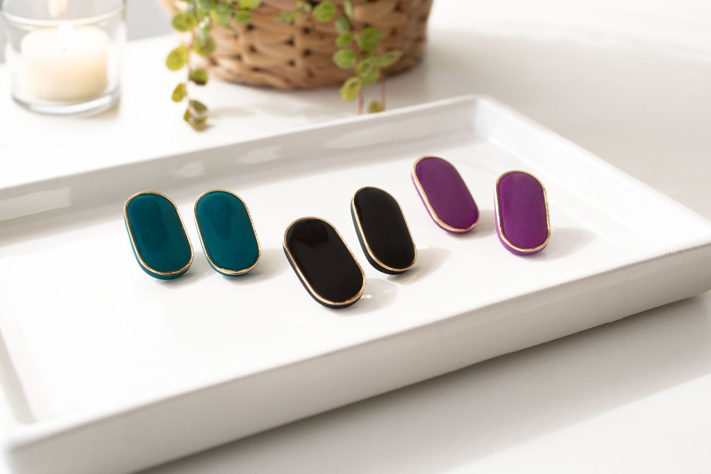 Geen black and purple stud earrings displayed on ceramic tray