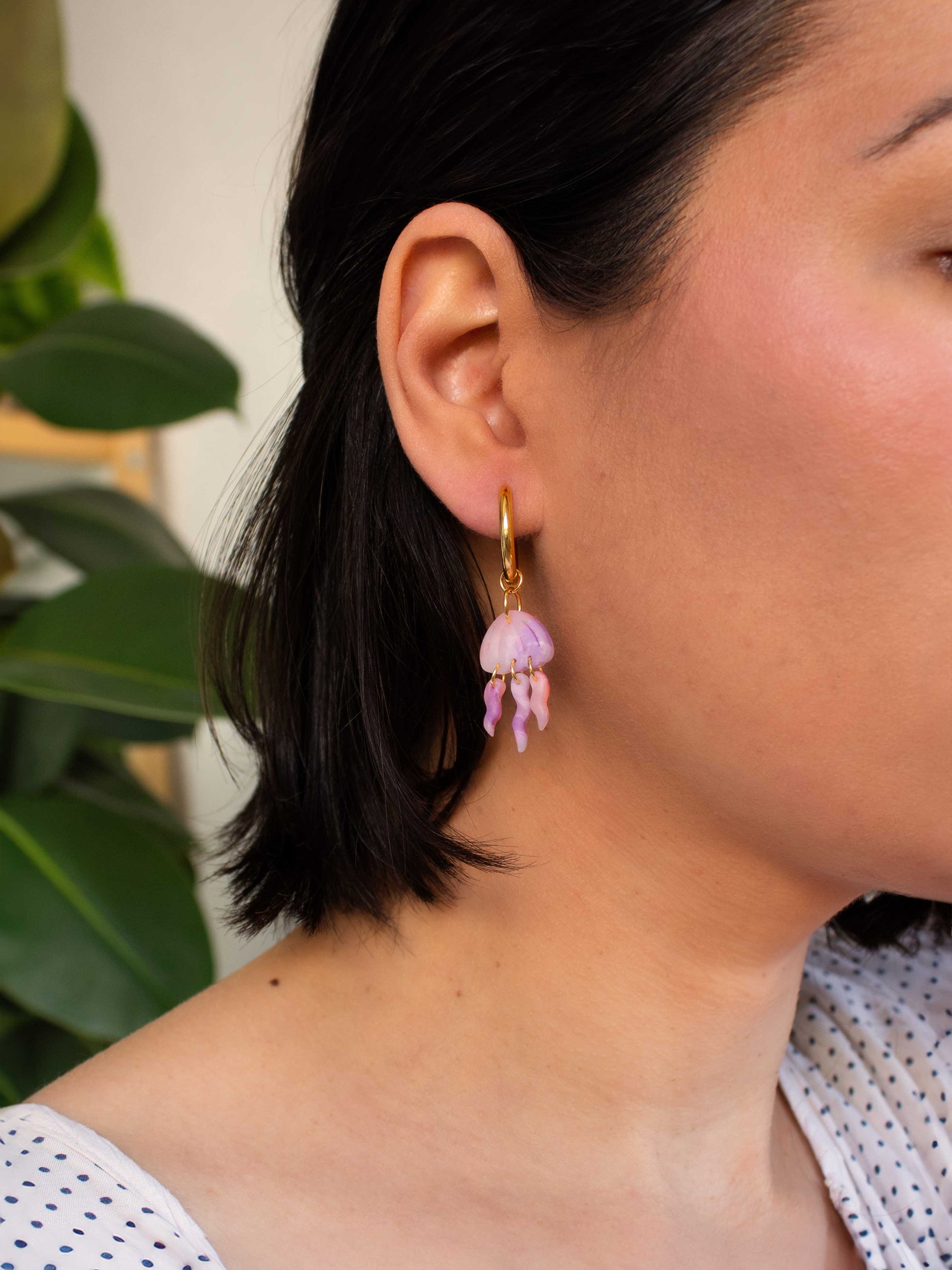 model wearing gold hoop earring with jellyfish charm beach vacation earrings