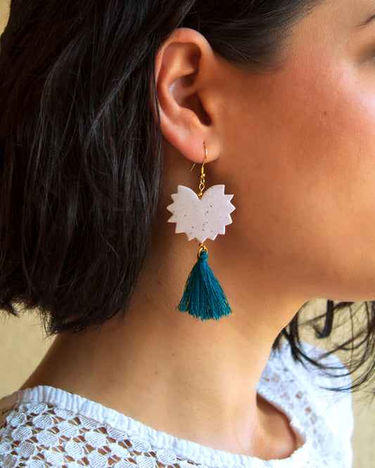 Woman wearing handmade clay tassel earrings, highlighting the elegant boho style.