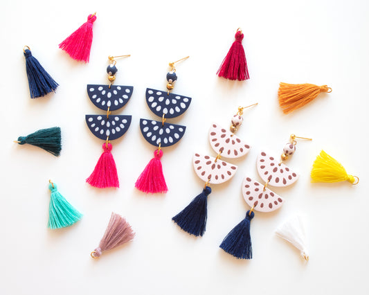 Handmade clay earrings in cream and navy with tassel details, featuring boho style design