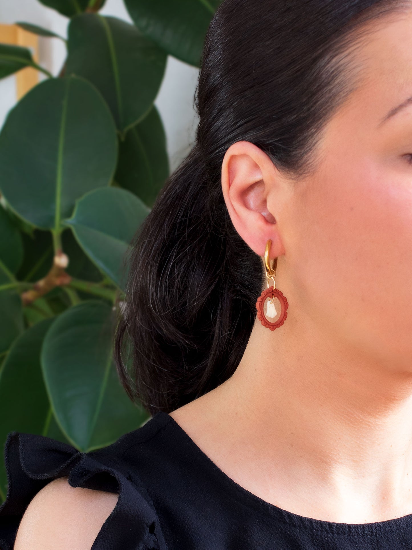 Model wearing a witchy Halloween charm hoop earring featuring a spooky ghost inside a red vintage frame pendant.